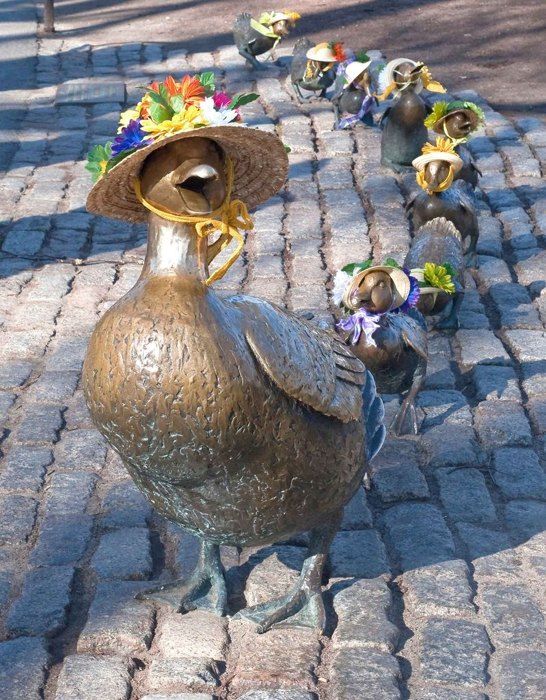 Bronze Mrs. Mallard and her ducklings wear sun hats decorated with flowers.