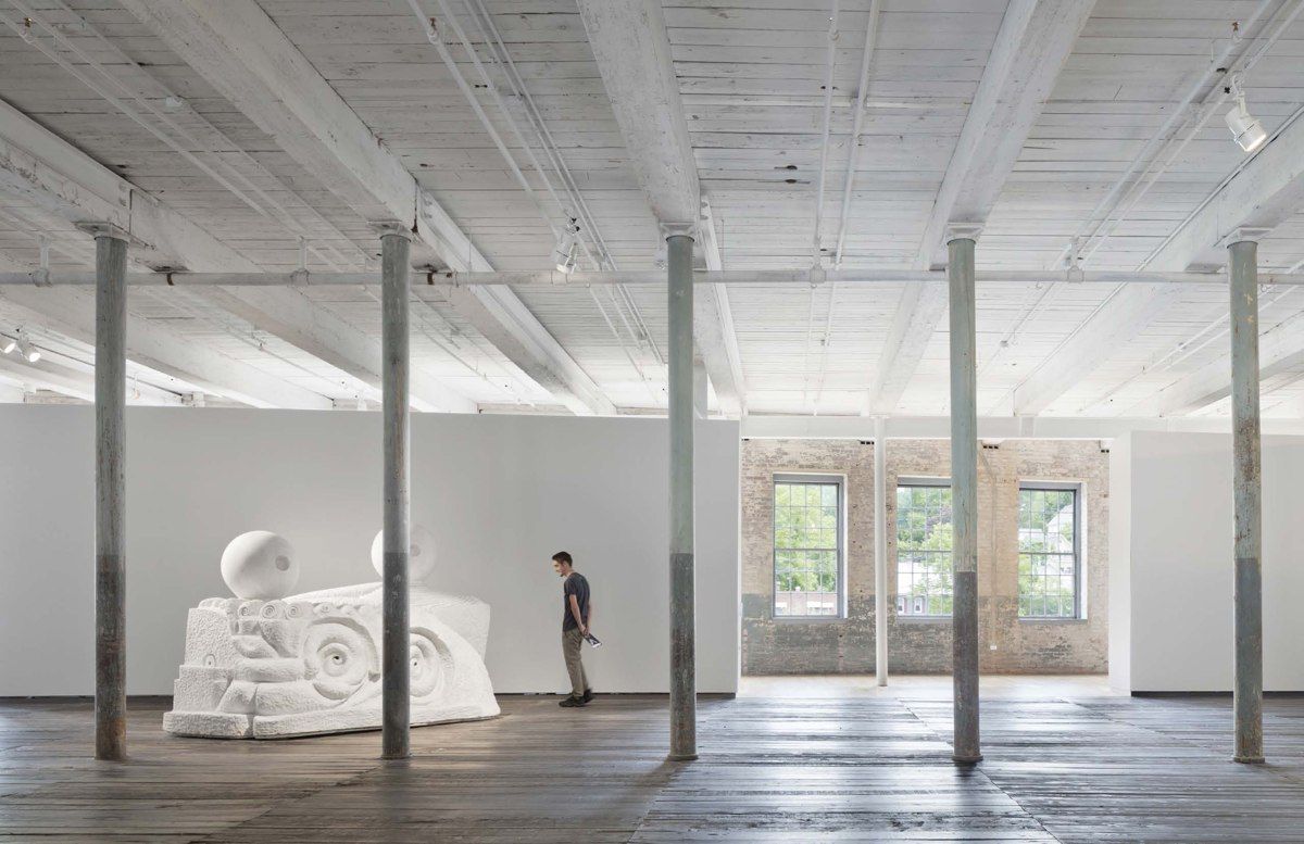 A visitor and a sculpture inside MASS MoCA’s Building 6, where former factory space became art galleries.