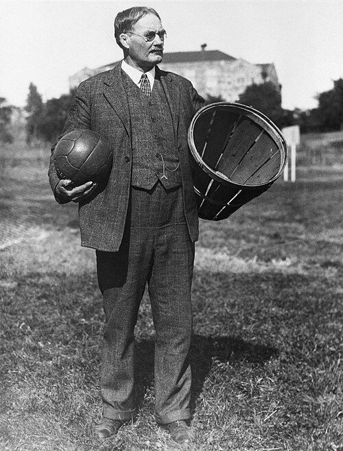 James Naismith holding a basketball and basket.
